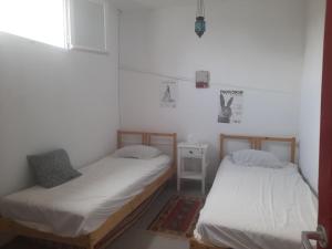 伊兹拉Maison charmante的带窗户的客房内设有两张单人床。