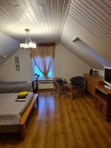 VilusiRähni Guesthouse Lake Peipsi的客厅配有床和桌椅