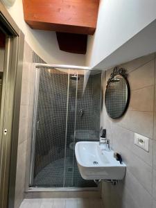 BovinoLa Dolce Vita的带淋浴、盥洗盆和镜子的浴室
