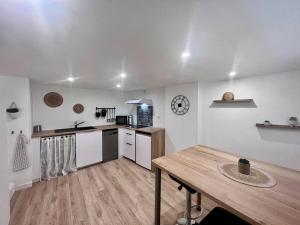 布里夫拉盖亚尔德Casa Bondy - Sublime T2 Refait à Neuf - Hyper Centre de Brive的厨房设有白色的墙壁和木桌