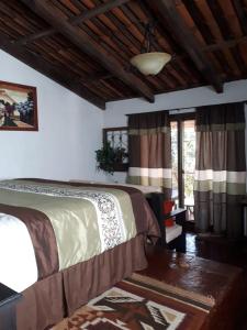 El TejarBosque Macadamia的一间卧室设有两张床、一张桌子和窗户。