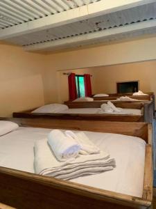 曼努埃尔安东尼奥Planet B Hostel - Adults Only的一间客房配有三张双层床和毛巾