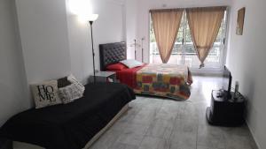布宜诺斯艾利斯Amplio departamento completo en Caba的一间卧室设有两张床、一张沙发和一个窗口