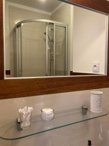 查普伊Villa Baltic Chałupy - Apartament nr 14A的一间带大镜子和玻璃水槽的浴室