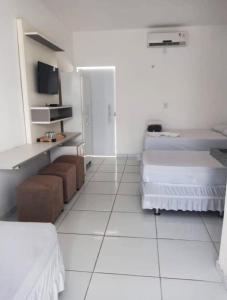 圣阿马鲁Ville Portal das Dunas Suites - St Amaro的白色的客房配有两张床和电视。