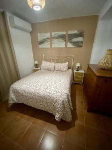 奥尔维拉Casa Rural Villa Briar的卧室配有一张床,墙上挂有两幅画