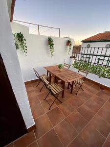 奥尔维拉Casa Rural Villa Briar的阳台的天井配有木桌和椅子