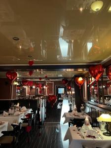 乌埃克尔明德AnaCapri Gästehaus Lugano的餐厅设有白色桌子和红色的天花板