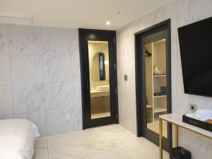 束草市Sokcho Business Hotel CAMEL的客房设有床、电视和浴室。