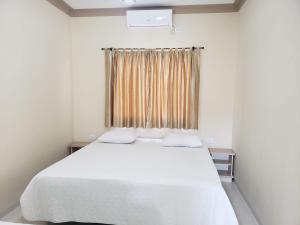 伊瓜苏Felipe Family Houses - Casas de temporada的卧室配有白色的床和窗户。
