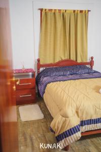 亚拉kunak的一间卧室配有一张床、一个梳妆台和一扇窗户。