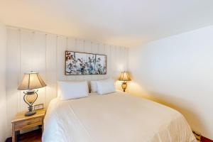 凯彻姆Ideal in Idaho的一间卧室配有一张带两盏灯的大型白色床。