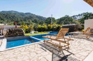 哈拉瓦科阿Sunflower village villa girasoles的一个带两把椅子的庭院和一个游泳池