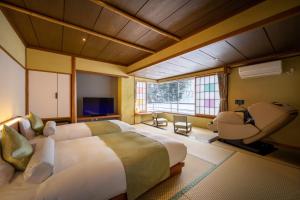 米泽市Onogawa Onsen Kajikaso的一间卧室设有一张大床和一个大窗户