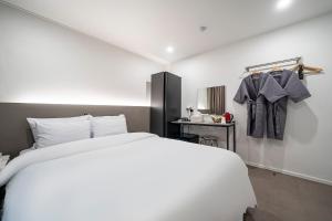 仁川市Jawoori Hotel Incheon Songdo的卧室配有白色大床和水槽