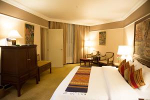 清莱威昂茵酒店的酒店客房带一张床、一张桌子和椅子