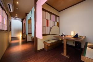 米泽市Onogawa Onsen Kajikaso的客房设有书桌和彩色玻璃窗。