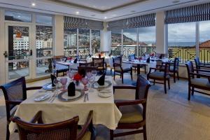丰沙尔奥尔葵迪亚酒店的用餐室设有桌椅和窗户。