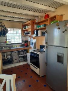 Las LajasLa Cima del Cielo的厨房配有不锈钢冰箱和炉灶。