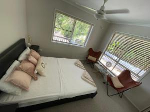 Cannon ValleyWhitsundays Bayview Escape的一间卧室配有一张带两把椅子的床和两个窗户