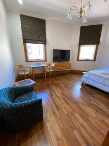 弗里曼特RIALTO SUITES Fremantle的一间卧室配有一张床、一张沙发和一台电视。