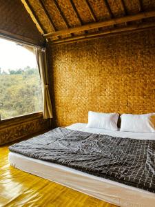 希维德Saung Arjuna Syandana Resort的一间卧室设有一张大床和窗户