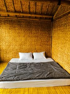 希维德Saung Arjuna Syandana Resort的砖墙房间的一个床位