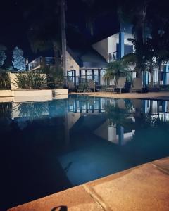 梅林布拉Nautilus Luxury Beach Apartment Merimbula的一座游泳池,在晚上在建筑物前