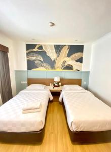 雅加达塞普塔酒店-瓦希德哈斯姆的卧室内的两张床,墙上有绘画作品