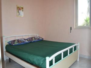 新福卡Central Holiday Home With Terrace And Garden; Parking Available的一间卧室配有一张带绿色床单的床和一扇窗户。