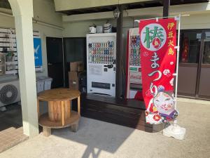大岛ゲストハウスKOIZUMI的一间商店,里面装有饮料冷却器和桌子