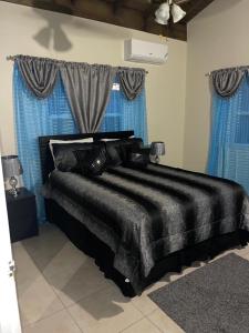 拉纳韦贝K&D EXCLUSIVE At the Vistas的一张黑色的床,房间配有蓝色窗帘