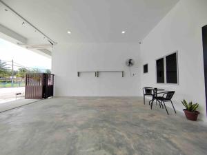 实兆远New Single Storey Homestay @ Sitiawan 3R2B (6-9PAX) _Feb Moment Homestay的白色的客房配有2把椅子和桌子