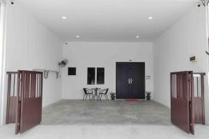 实兆远New Single Storey Homestay @ Sitiawan 3R2B (6-9PAX) _Feb Moment Homestay的一间白色的大房间,设有两扇门和椅子