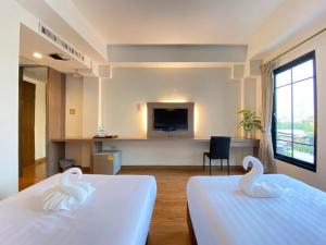 Ban Khlong PrawetView Dee BKK Airport Residence的两间天鹅,在旅馆房间两张床上