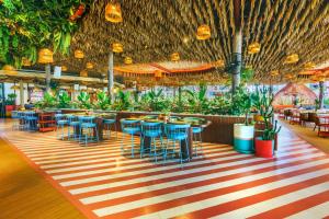 芭堤雅市中心芭堤雅A1皇家游轮酒店 - SHA Extra Plus的一间设有桌椅的餐厅,种植了植物