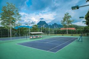 和平VResort Kim Boi - Hoa Binh的一座以树木和山脉为背景的网球场
