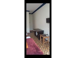 乌德尔格希Hotel Krish Motel and Restaurant, Uttarkashi的配有床和桌子的房间