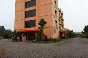 雅加达Hotel 678 Cawang powered by Cocotel的前面有一棵树的大建筑