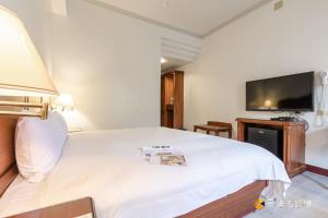礁溪春和大饭店的卧室配有一张白色大床和一台平面电视。