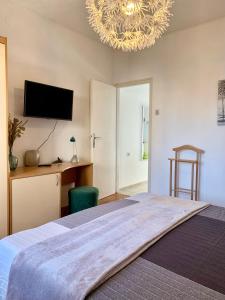 乌马格Seafront Apartment Jadri的一间卧室配有一张大床和一个吊灯。