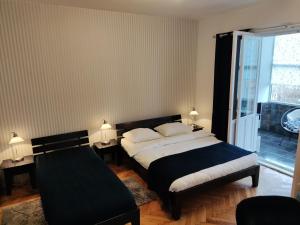贝尔格莱德精选客房旅馆的一间卧室设有一张大床和一个窗户。