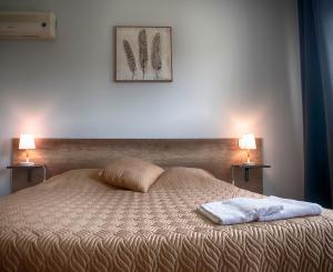 欧兹Hôtel LES LODGES D'EAUZE的一间卧室配有一张带两盏灯的床。