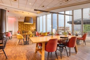 梅赫伦梅赫伦市中心快捷假日酒店的餐厅设有桌椅和窗户。