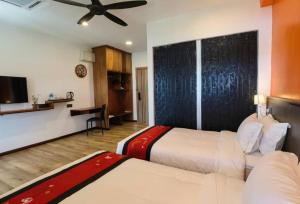哥打京那巴鲁科科尔避风港度假村的一间酒店客房,设有两张床和电视