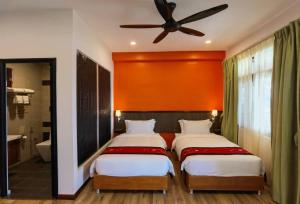 哥打京那巴鲁科科尔避风港度假村的一间卧室配有两张床和吊扇