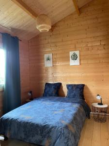 GiromagnyÔ Village的木制客房内的一间卧室,配有一张床