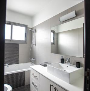 尼科西亚Glabur Stays - The Amazing 2 BDR - Nicosia City, Free Parking & WiFi的白色的浴室设有水槽和浴缸。