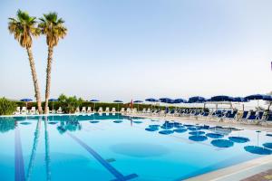 曼达托里乔码头天堂村酒店的一个带椅子和棕榈树的大型游泳池