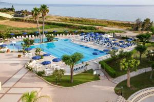 曼达托里乔码头天堂村酒店的享有带椅子和遮阳伞的游泳池的上方景致